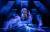 Renée Lamb onstage with dark blue lighting around them